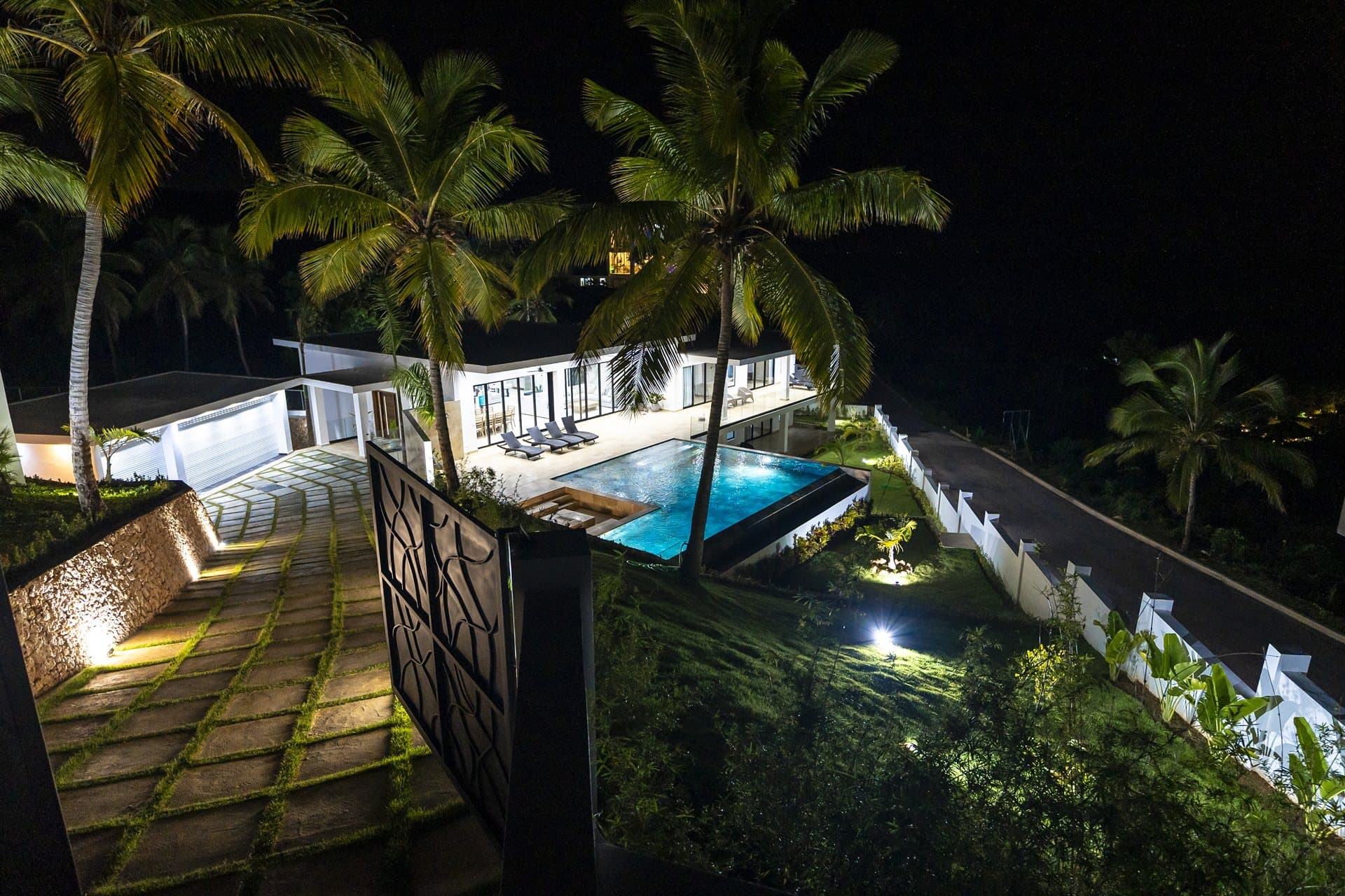 Área social exterior y piscina iluminada de noche